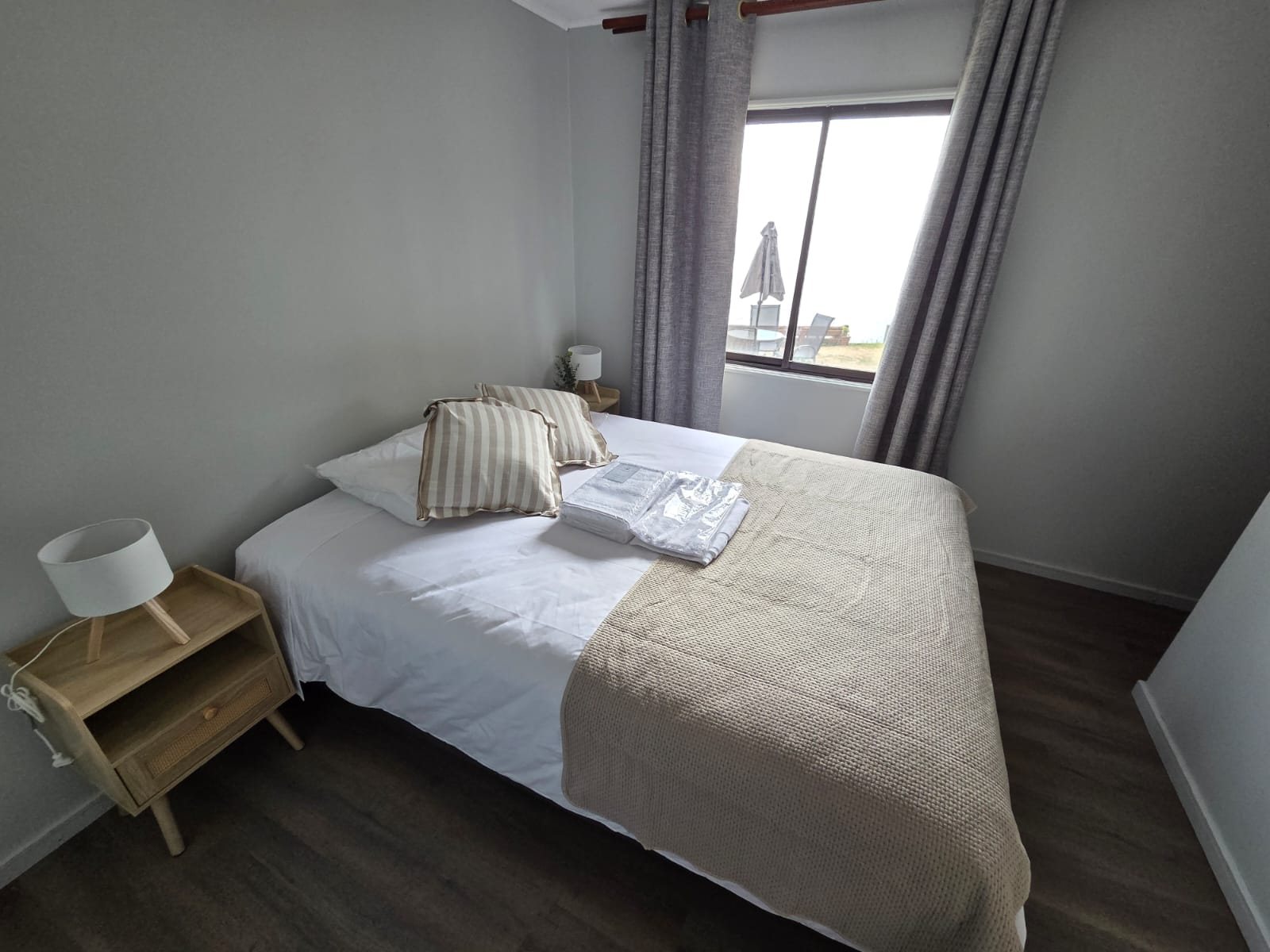 Habitación Doble con cama matrimonial y ventana hacia la terraza y el mar