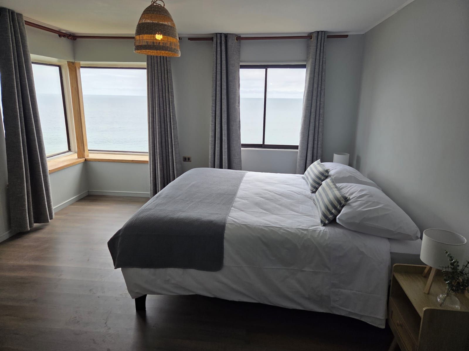 Habitación con cama matrimonial y ventanales en esquina hacia el Pacífico